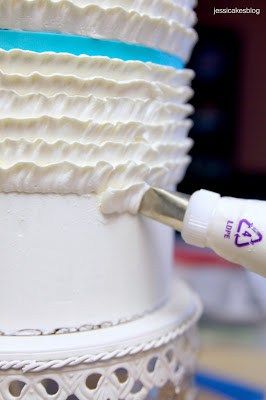 a close up of a white cake with icing on it and a brush in the middle