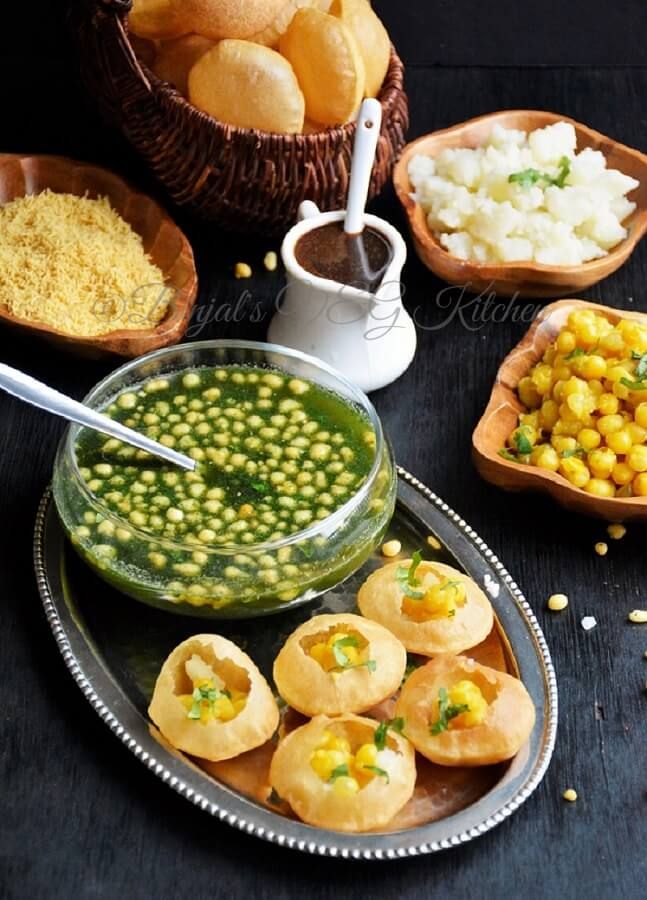 some food is sitting on a table with bowls and spoons next to the dishes