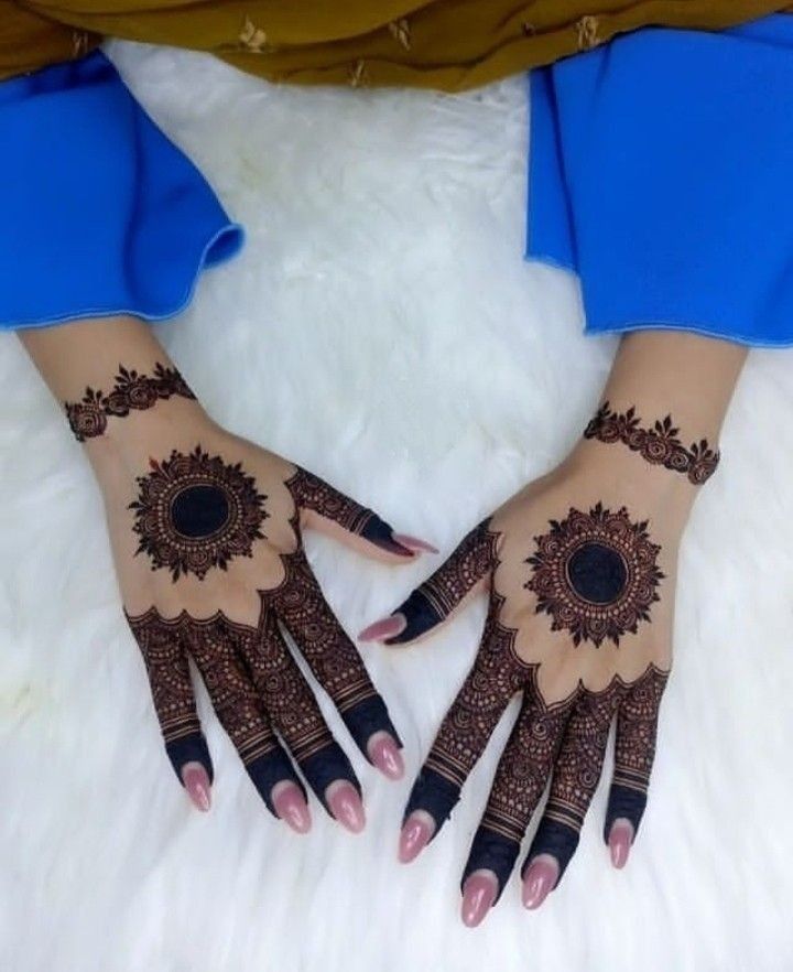 two hands with henna designs on them