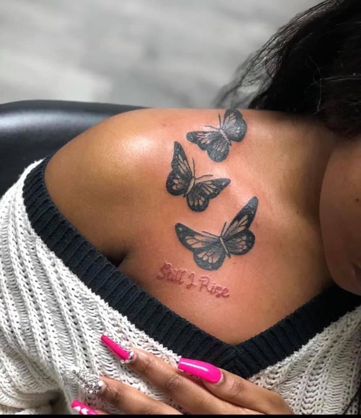 a woman with butterflies on her shoulder and the words believe free tattooed on her chest