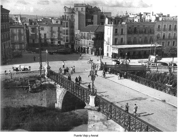 an old black and white photo of people walking on a bridge over a city street