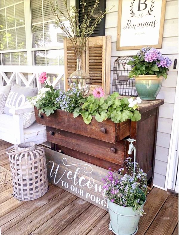 a wooden box filled with flowers sitting on top of a porch