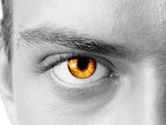 a man's eye with an orange iris