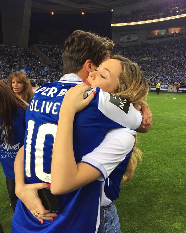 two people hugging each other at a soccer game