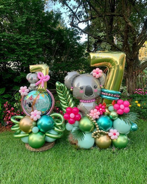 some balloons are in the shape of numbers and animals with flowers on them, including a koala bear