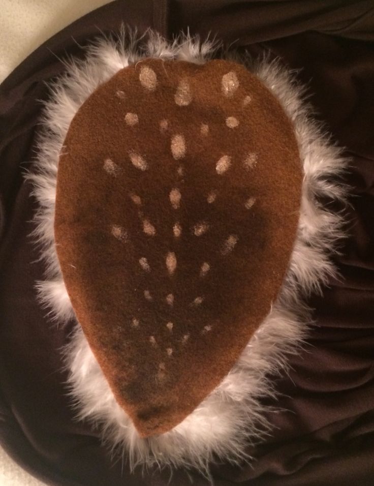 a brown heart with white spots on it sitting on top of a black cloth bag