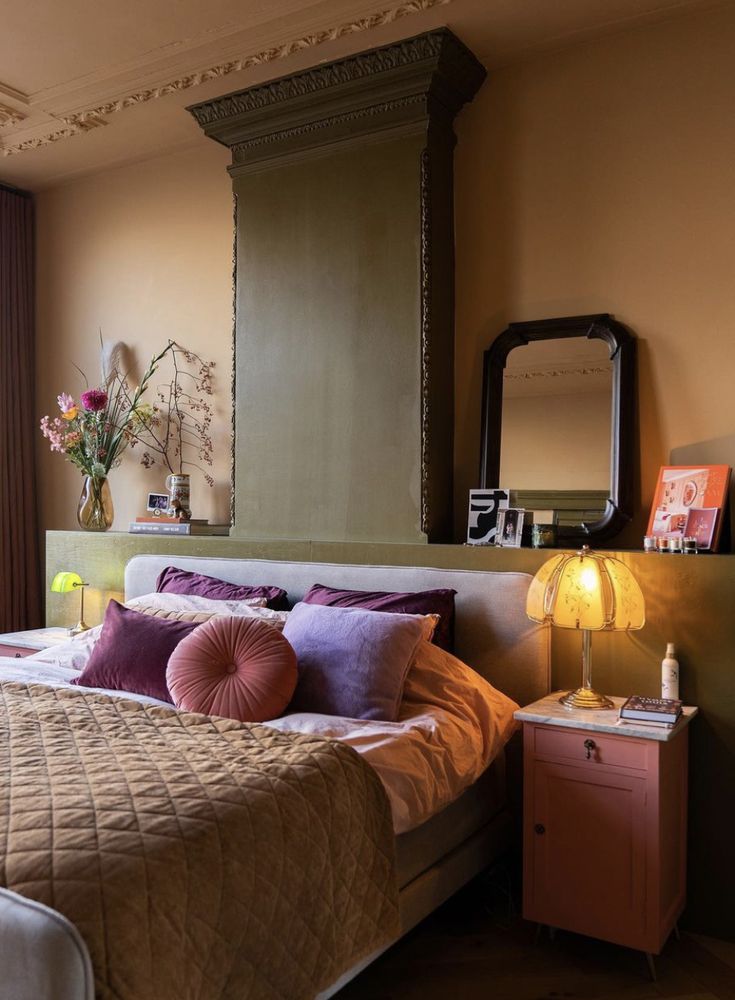 a bed room with a neatly made bed next to a window and a large mirror