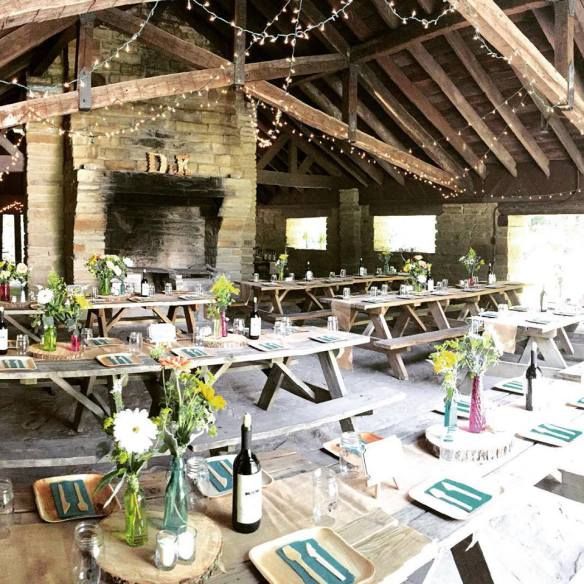 tables and benches are set up in an old barn