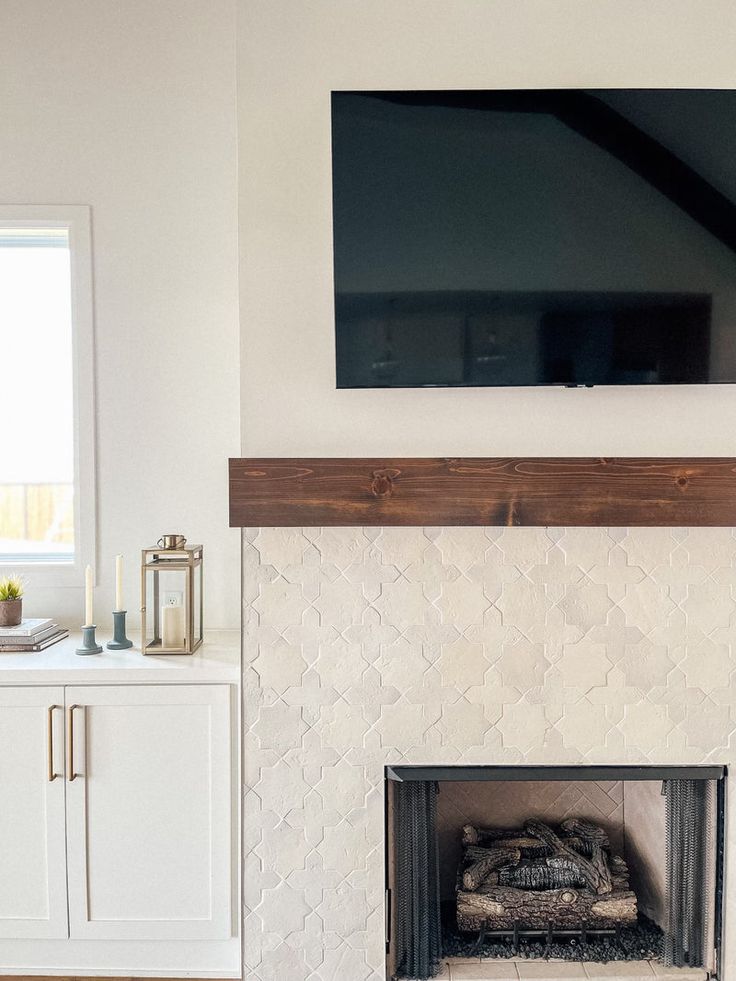 a flat screen tv mounted above a fireplace in a living room