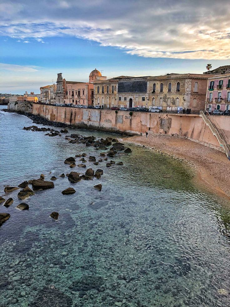 the water is crystal clear and there are many buildings on the shore