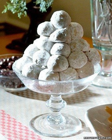 a glass bowl filled with snowballs on top of a table next to other dishes