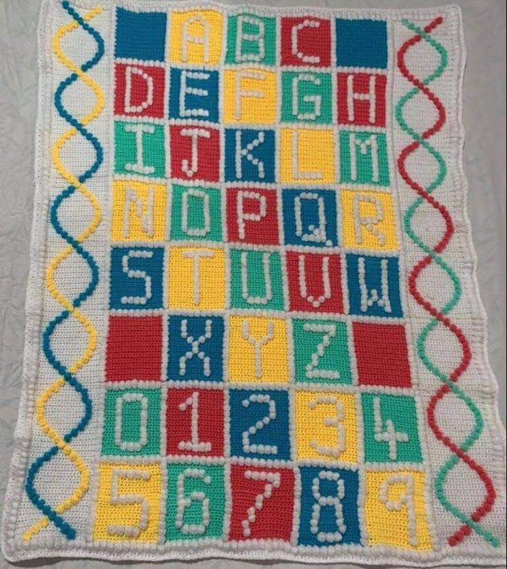 a crocheted blanket with letters and numbers in different colors on the bottom half