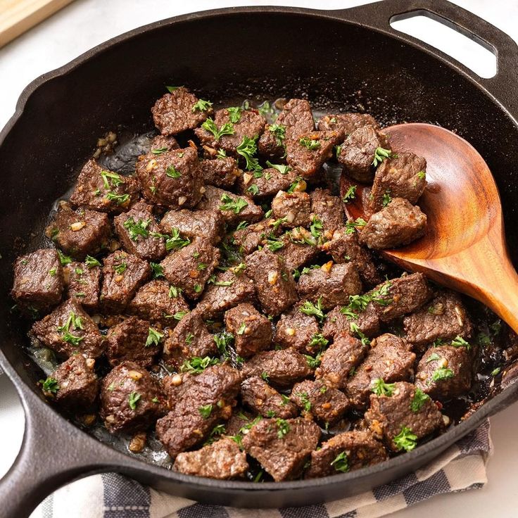 a skillet with meat and parsley in it