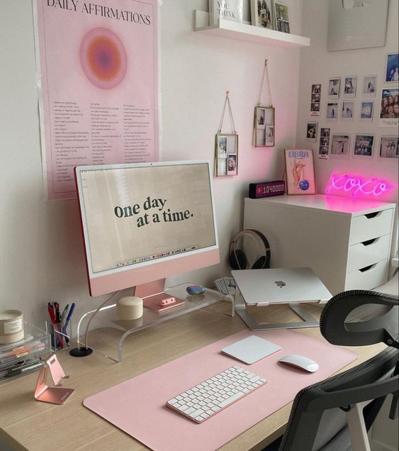 a desk with a computer on top of it and a pink sign above the keyboard