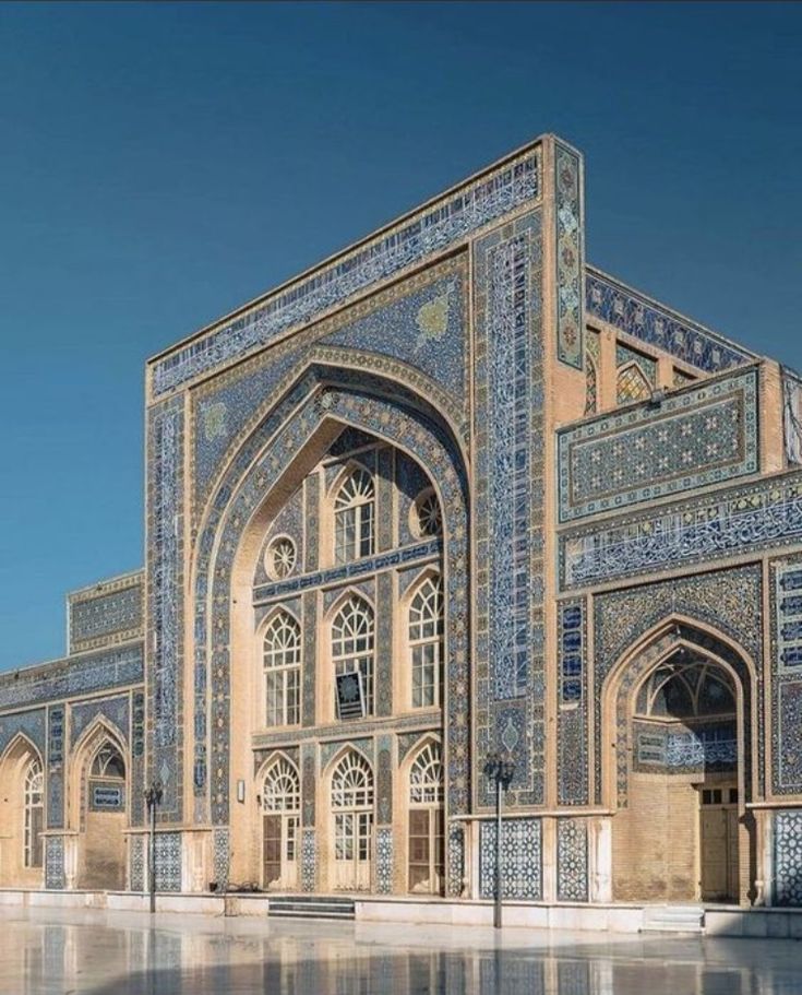 an intricately designed building with blue tiles on it's walls and windows, in the middle of a courtyard