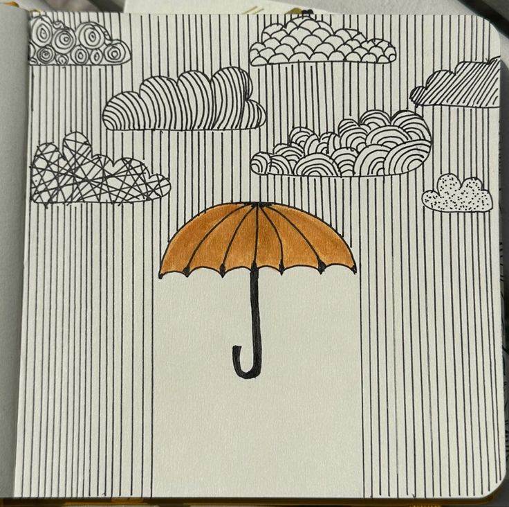 a drawing of an umbrella with clouds and rain in the background on a piece of paper