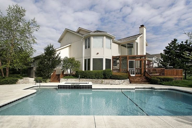 a house with a swimming pool in front of it and stairs leading to the upper level