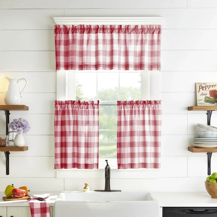 a kitchen with red and white checkered curtains hanging on the window sill, next to a sink