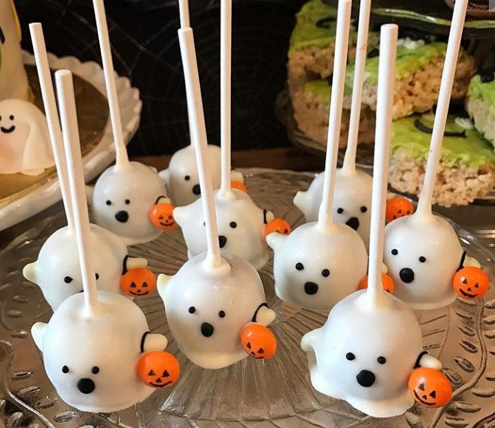 halloween cake pops with white frosting and orange candies in the shape of ghost heads