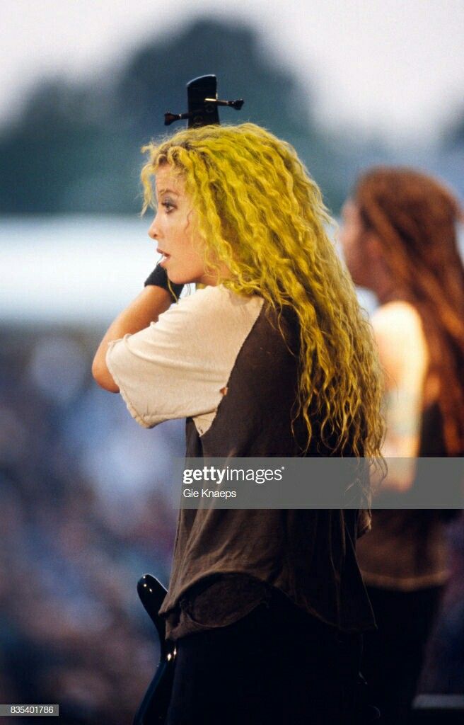 the blond haired singer performs on stage at an outdoor concert in front of a crowd