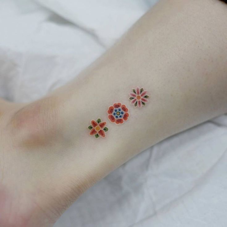 a person with a flower tattoo on their left foot and the rest of her arm