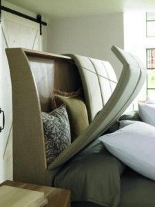 a bed that has some pillows on it and is in the shape of a curved headboard