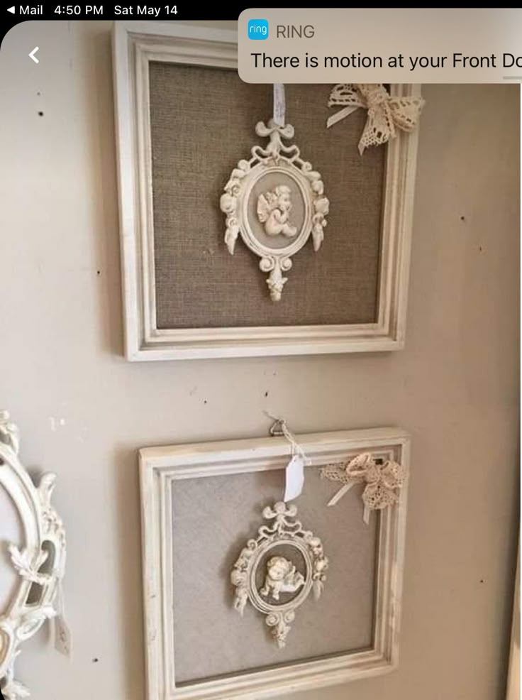 three framed pictures hanging on the wall in a room with white trimming and lace