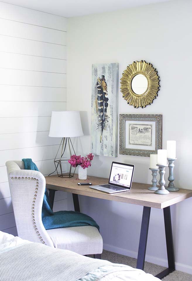 a desk with a laptop computer on top of it next to a chair and lamp