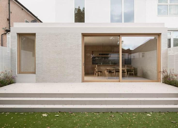 a modern house with sliding glass doors on the outside