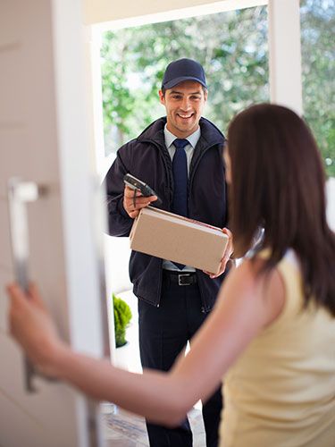 a man is holding a cardboard box and looking at the woman in front of him