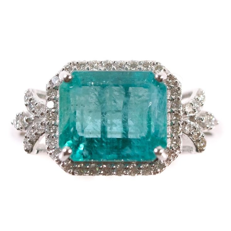 an emerald and diamond ring with diamonds around it