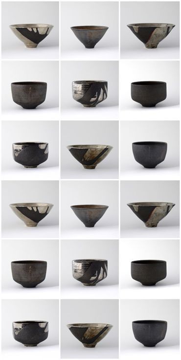 many black bowls are arranged in rows on a white surface, each with different shapes and sizes