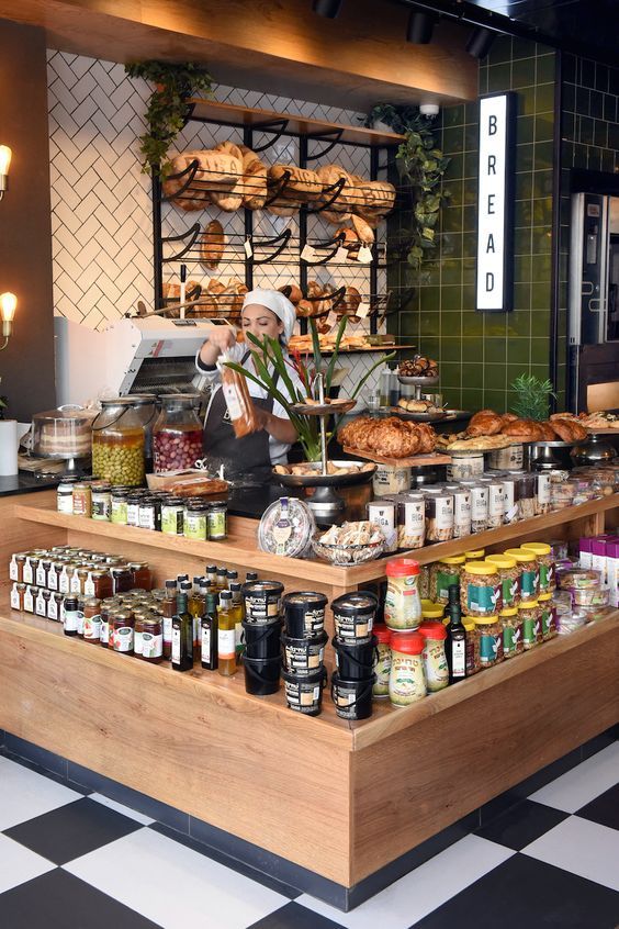 a counter with food on it in a restaurant or bar area next to a black and white checkered floor