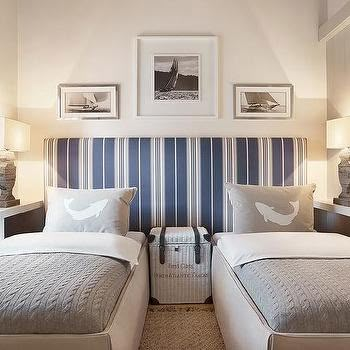 two twin beds in a room with pictures on the wall