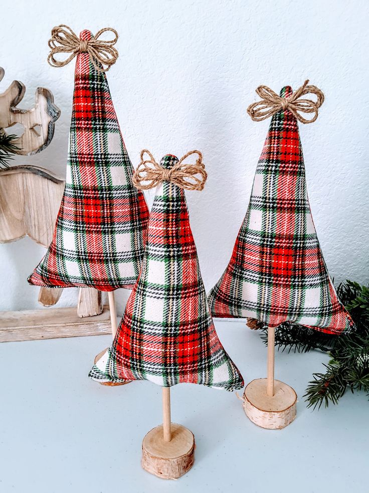 three wooden christmas trees with bows on them