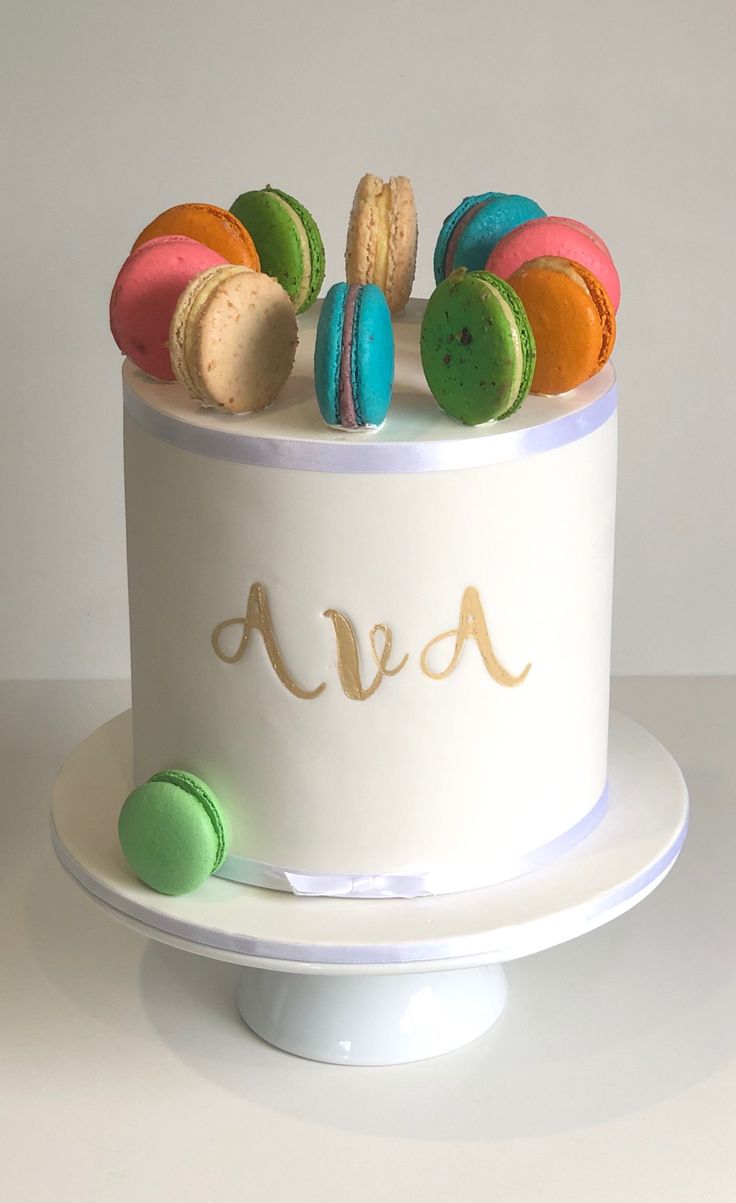 a white cake with colorful macaroons on top