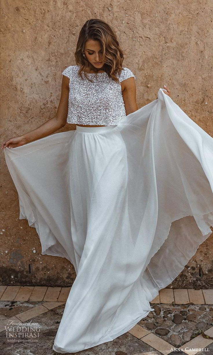 a woman wearing a white skirt and crop top