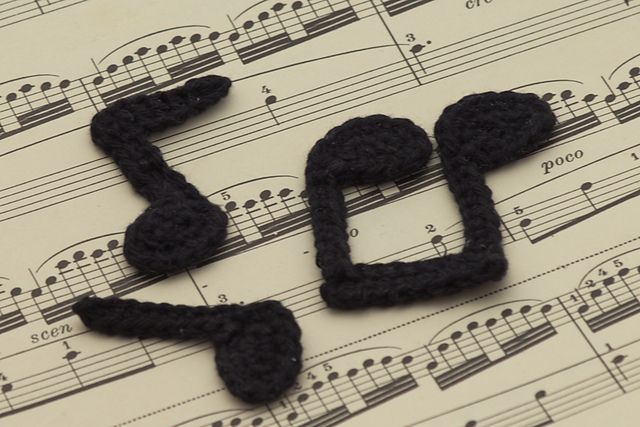 some music notes with black crochet on them