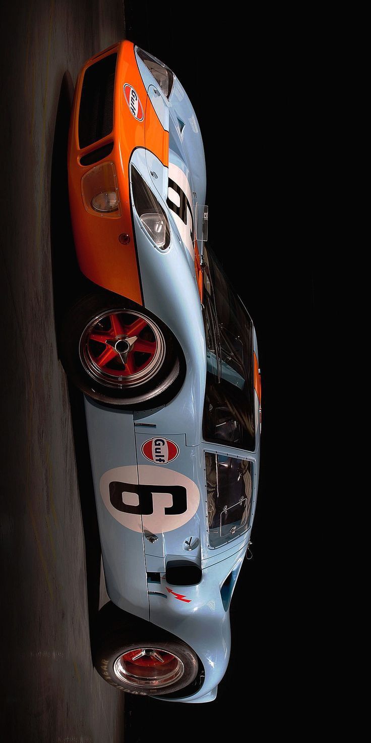 an orange and blue race car parked in the dark