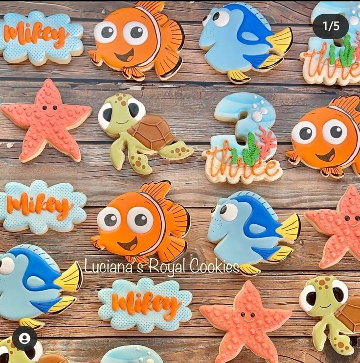 decorated cookies are arranged in the shape of fish and sea animals on a wooden table