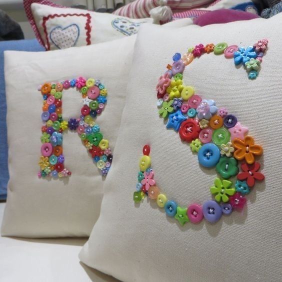 two pillows that have buttons on them and the letters d and r are made out of fabric