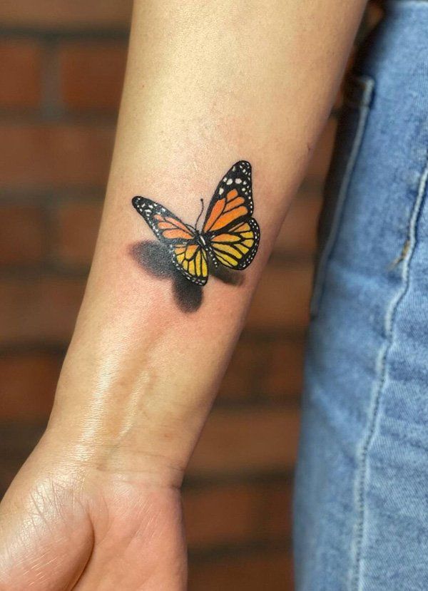 a woman's arm with a small butterfly tattoo on the left side of her wrist