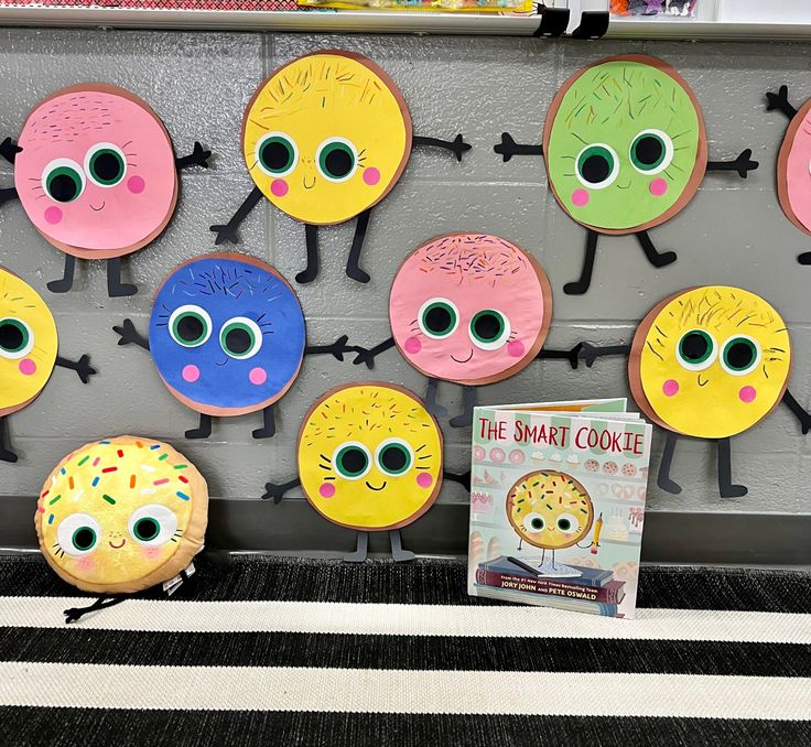 some paper plates that have eyes and donuts on them with a book next to it