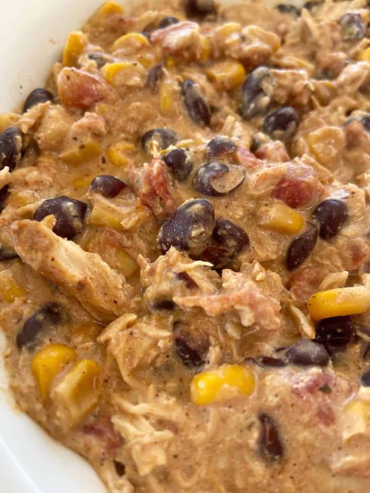 a casserole dish with black beans, corn and meat