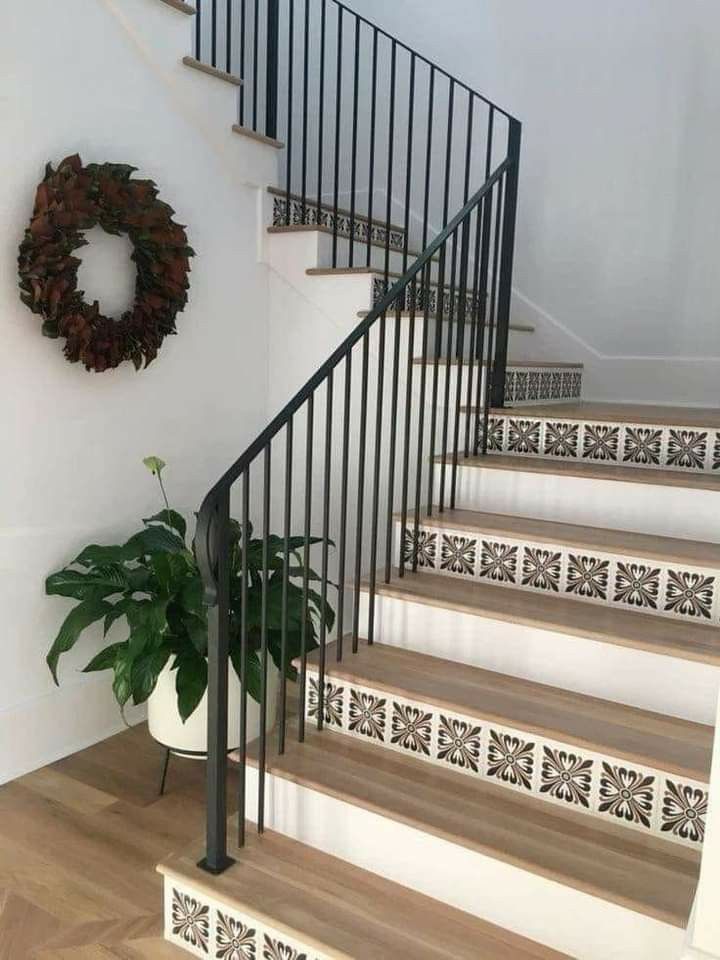 the stairs are decorated with black and white designs, along with a potted plant