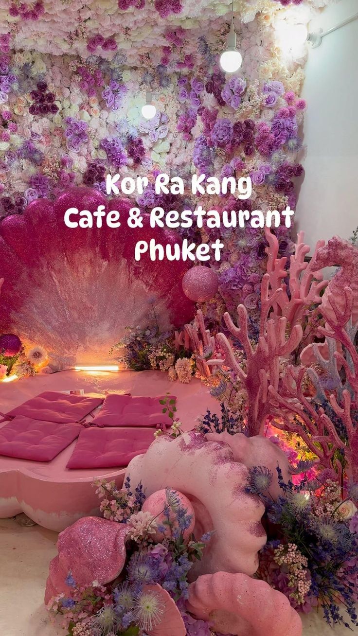 the interior of a restaurant decorated in pink and purple colors with seaweed, corals and other plants