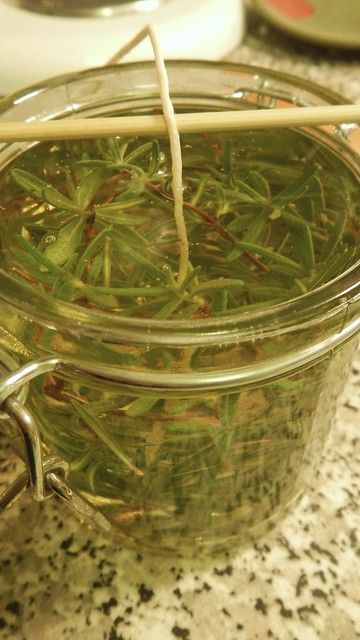 a glass jar filled with green tea sitting on top of a counter next to a wooden spoon