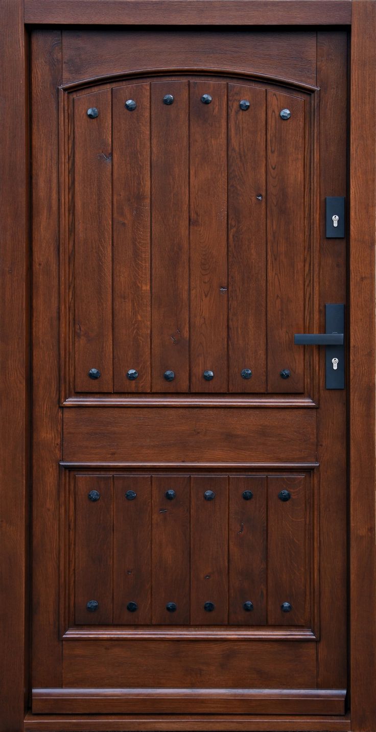 a close up of a wooden door with metal handles