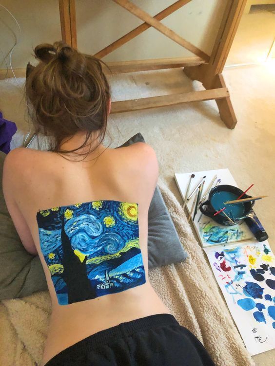 a woman sitting on the floor with her back turned to look like she is painting