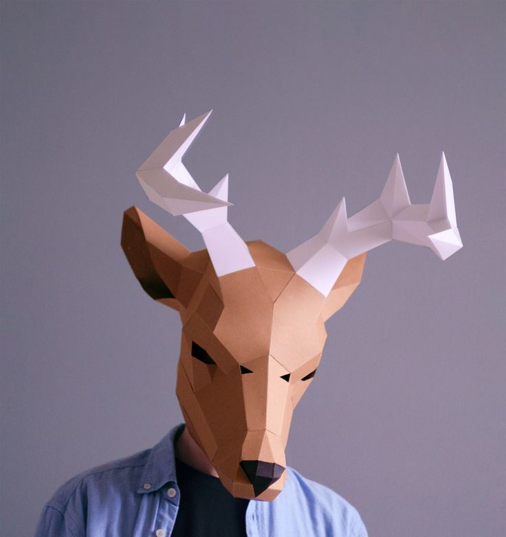 a man wearing a paper deer mask with long horns on his head and eyes closed